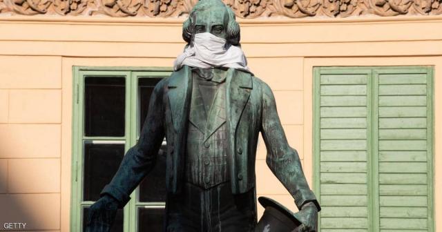 تمثال يوهان نيستروي في فيينا يرتدي قناعا خلال تفشي كورونا