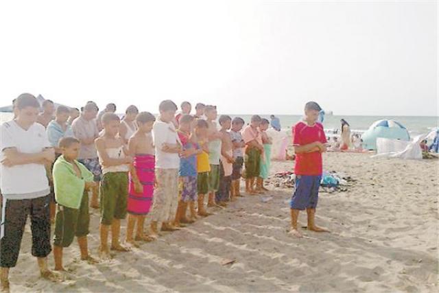 المصطافون يؤدون الصلاة على الشاطئ