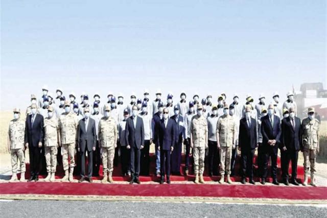 الرئيس السيسى يتوسط عددًا من المسؤولين ورجال القوات المسلحة أثناء إطلاق إشارة حصاد القمح فى توشكى